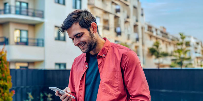 Smiling man looking at his phone.